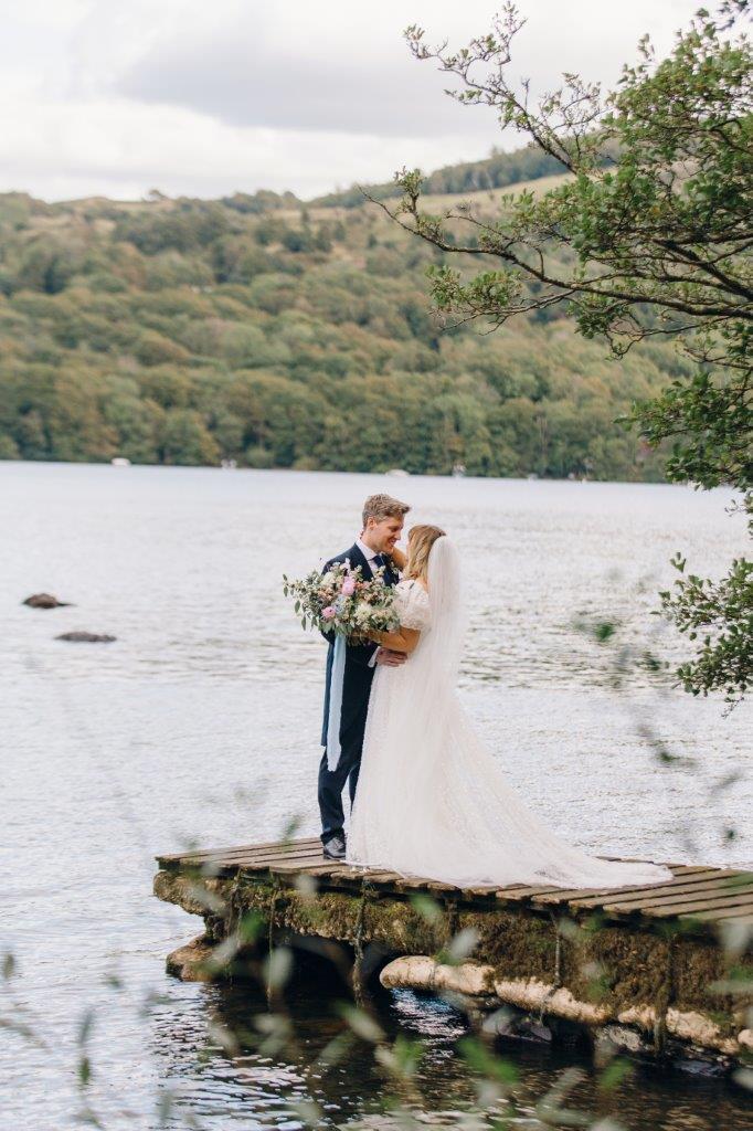 Newlyweds on the banks of lake Windermere, Lake District wedding