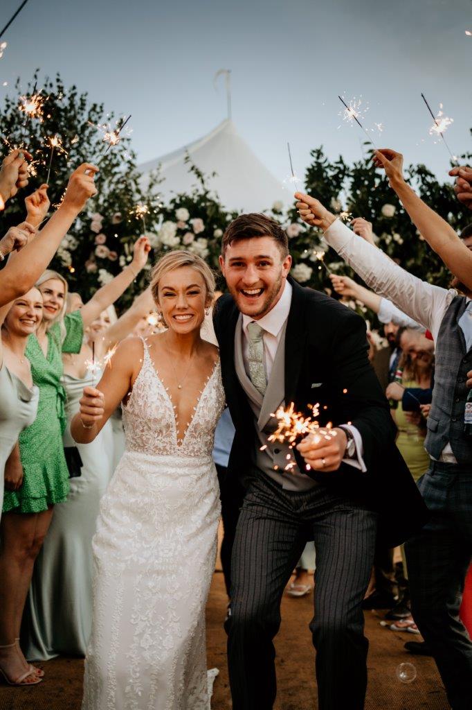Happy couple at their Sailcloth Tent Marquee Wedding - sparkler shot image